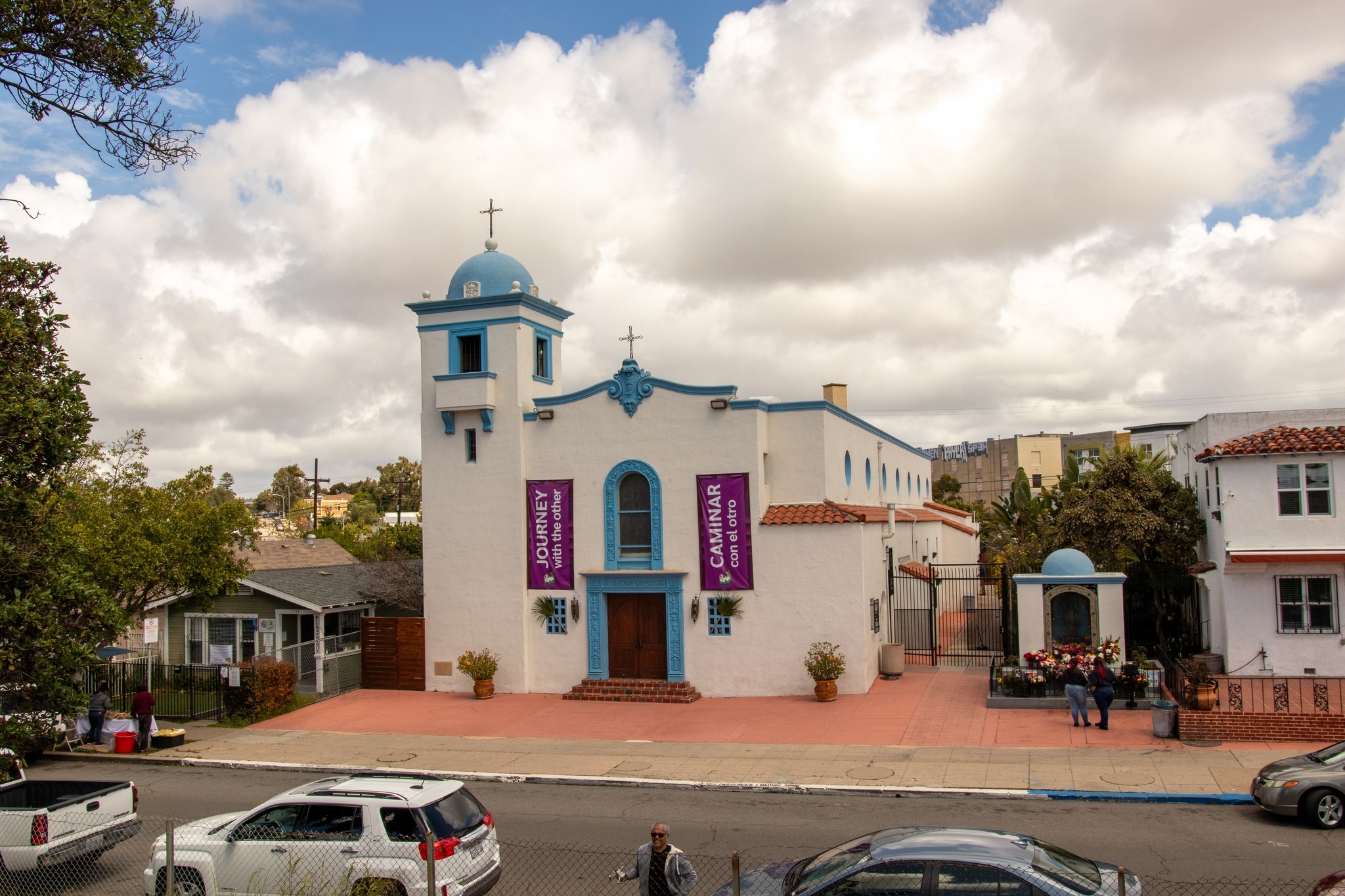 Our Lady of Guadalupe parish church featuring distinctive white and blue architecture with red brick plaza entrance.
