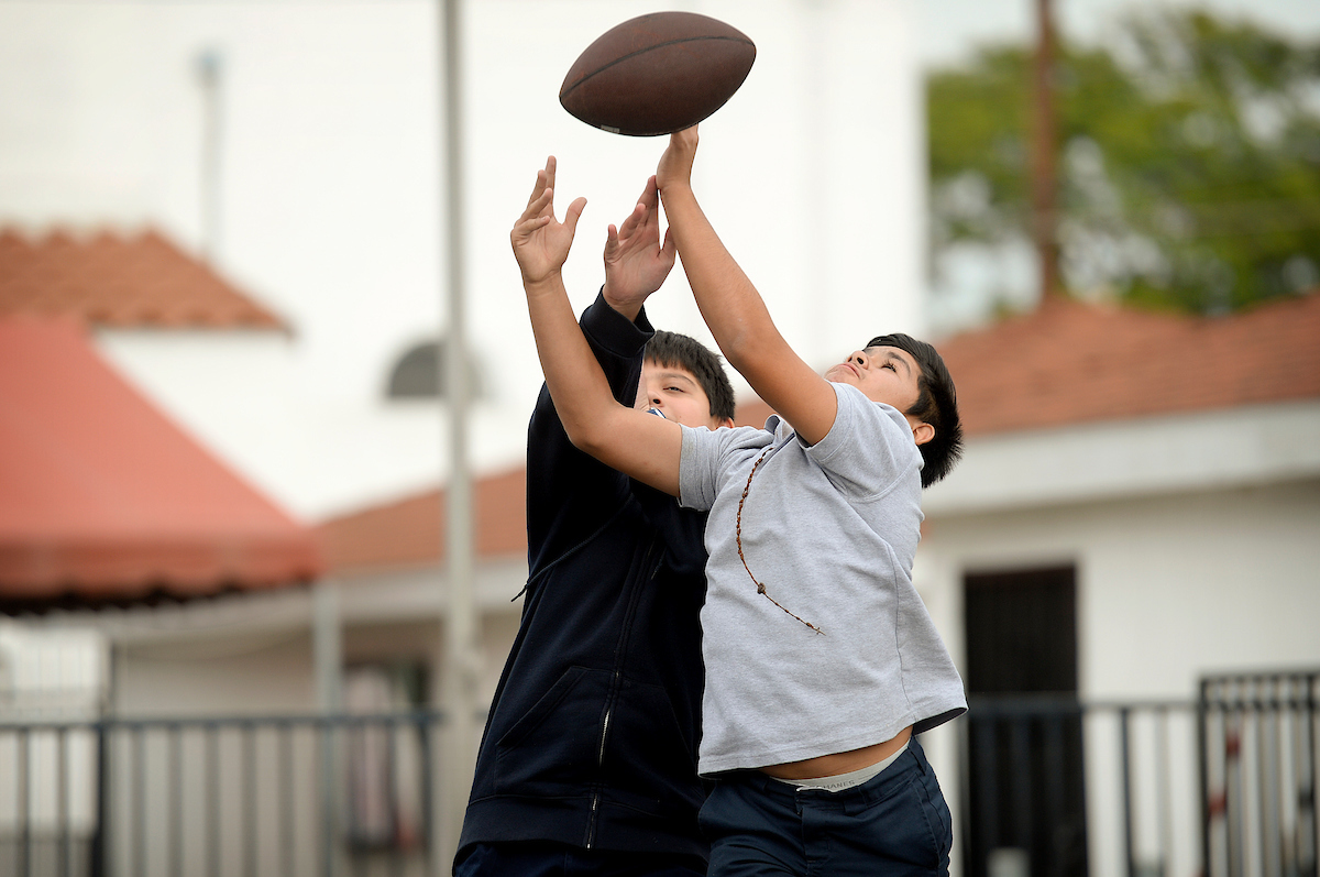 Young teenage boys playing basketball.